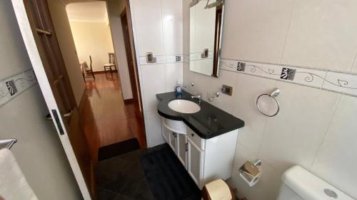een badkamer met een wastafel en een spiegel bij Departamento independiente centrico in Cochabamba