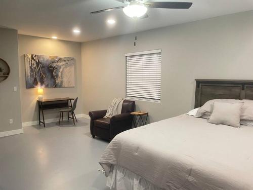 een slaapkamer met een bed, een stoel en een bureau bij Desert Ranch Home 3 Bedroom + Equine Facility in Vail