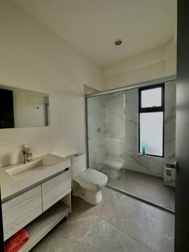 a bathroom with a toilet and a sink and a shower at Torre Q Mazatlán - Departamento cerca del malecón de Mazatlán in Mazatlán
