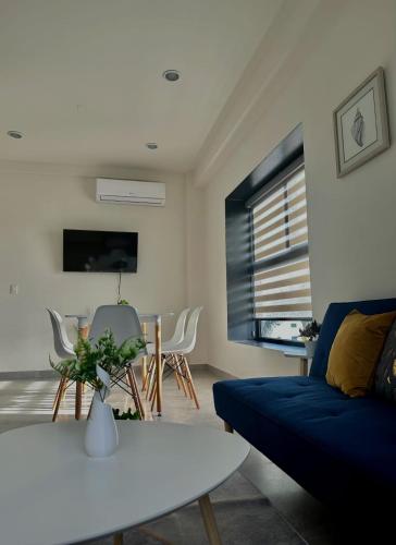 a living room with a blue couch and a table at Torre Q Mazatlán - Departamento cerca del malecón de Mazatlán in Mazatlán