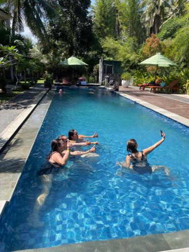a group of people swimming in a swimming pool at Red island villas in Banyuwangi