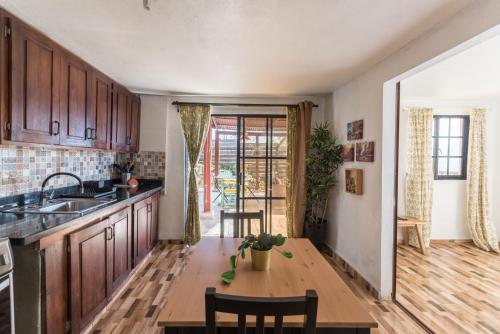 uma cozinha com armários de madeira e uma mesa com cadeiras em Altos de Chulavista Constanza em Constanza