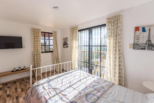 a bedroom with a bed and a large window at Altos de Chulavista Constanza in Constanza