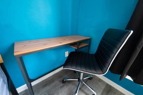 un bureau et une chaise à côté d'un mur bleu dans l'établissement Cozy Hollywood Get Away, à Los Angeles