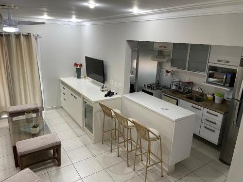 - une cuisine avec un comptoir et des chaises dans la chambre dans l'établissement Cobertura Ilha da Madeira, à Riviera de São Lourenço