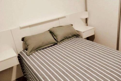 1 cama con 2 almohadas en una habitación en Excelente depto en Rosario en Rosario