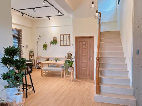 a hallway with stairs in a home with a table at Gardenstay in Luodong