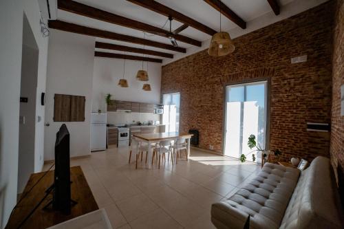 a living room and kitchen with a brick wall at La Boya Departamentos in La Paz