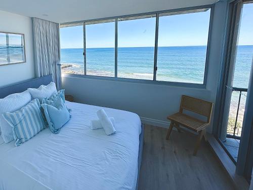a bedroom with a bed with a view of the ocean at Monterey Lodge - Unit 18, 27 Warne Terrace, Kings Beach Caloundra in Caloundra