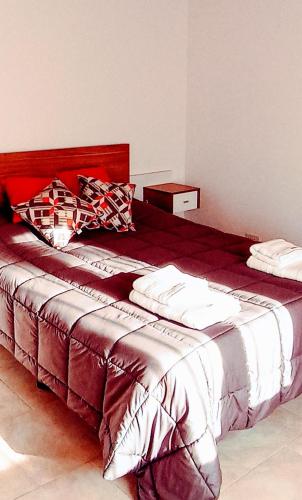 1 dormitorio con 1 cama grande y cabecero rojo en Duplex Esquel en Esquel
