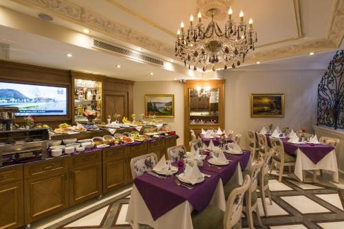 a restaurant with purple tables and chairs and a chandelier at GLK PREMIER Sea Mansion Suites & Spa - Special Class in Istanbul