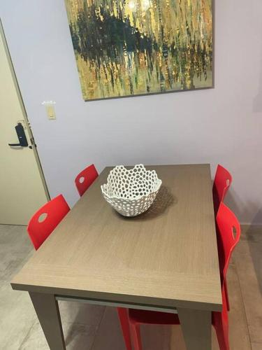 a wooden table with red chairs and a bowl on it at Beach Front Condo in Isla Verde! in San Juan