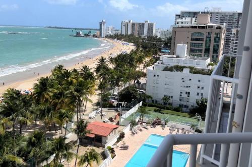 サンファンにあるOcean Front Condo in Isla Verde!のリゾートのバルコニーからビーチの景色を望めます。