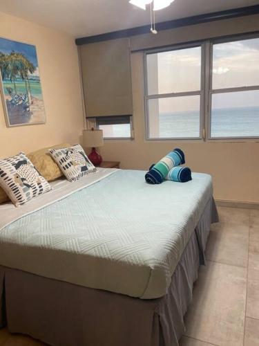 a bedroom with two beds and a large window at Beach Front Condo in Isla Verde! in San Juan
