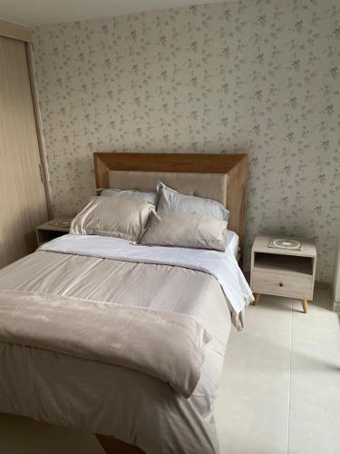 a bedroom with a bed and a side table at Hermoso apartamento en Armenia Quindio in Armenia