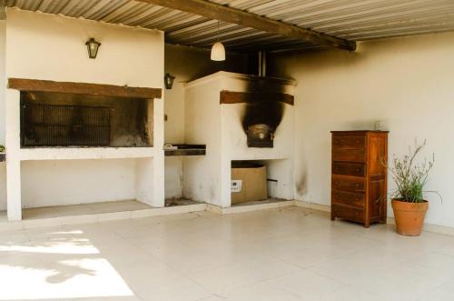 a living room with a fireplace and a wooden cabinet at Complejo Mis Pumitas in La Banda