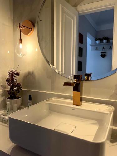 a white bathroom with a tub and a mirror at Flat Centro de Capivari in Campos do Jordão