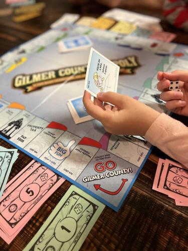 a child playing a game with a card on a table at Less than 3 miles to Downtown with firepit in Ellijay