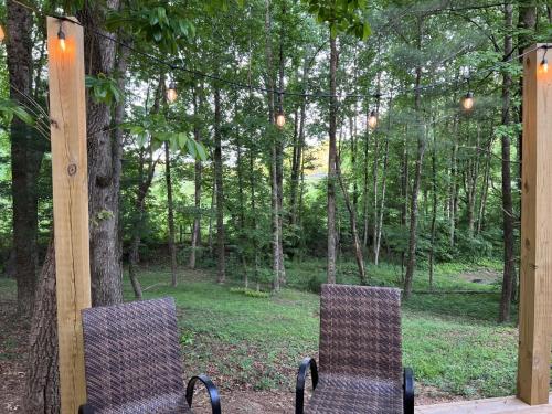 two chairs sitting in front of a forest at Less than 3 miles to Downtown with firepit in Ellijay