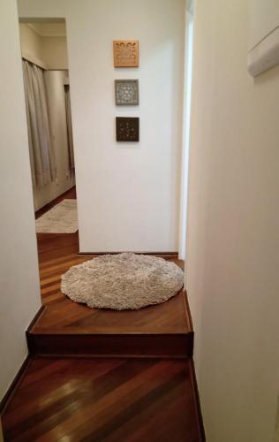 a white room with a rug on a wooden floor at Flat Centro de Capivari in Campos do Jordão