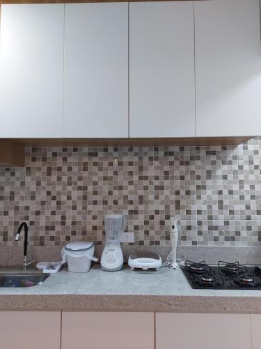 a kitchen counter with a blender and a sink at Apto aconchegante pé na areia in Guarujá