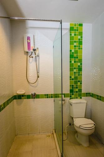 a bathroom with a toilet and a glass shower at Embryo Hotel  in Pattaya Central