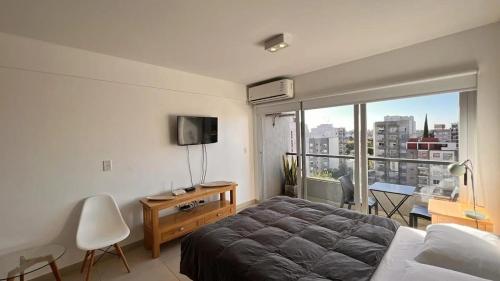 sypialnia z łóżkiem i widokiem na miasto w obiekcie machado apartamentos moron w mieście Morón