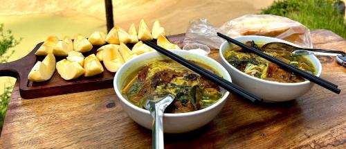 een tafel met twee kommen eten en een bord brood bij Thang Hen Lake - Thang Hen Glamping & Eco Outdoor in Thăng Hen