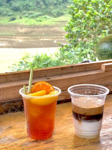 Twee drankjes staan op een tafeltje naast een raam. bij Thang Hen Lake - Thang Hen Glamping & Eco Outdoor in Thăng Hen