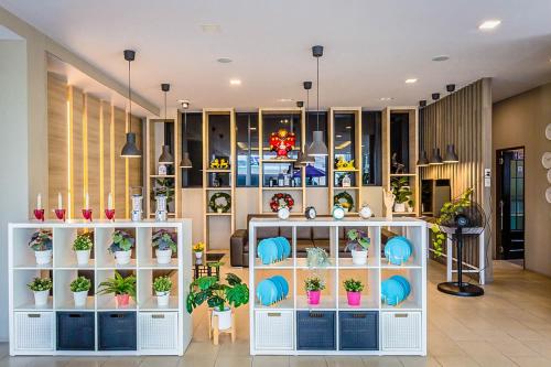 a store with potted plants on shelves in a room at Embryo Hotel  in Pattaya Central