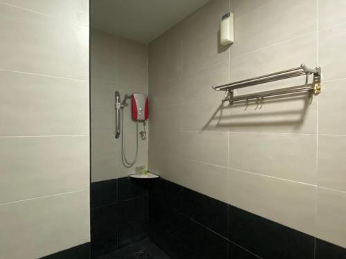 a bathroom with a shower with a phone on the wall at D&F BOUTIQUE HOTEL SENAWANG in Senawang