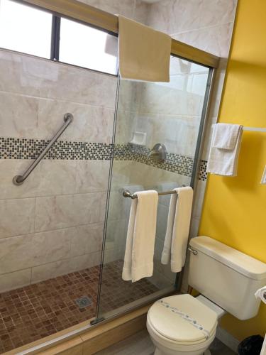 a bathroom with a glass shower with a toilet at 777 Motor Inn in Huntington Beach