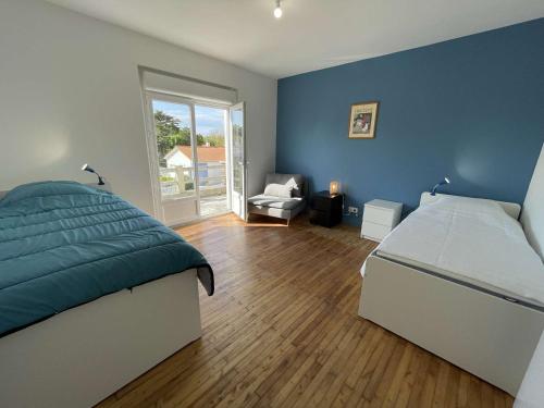 a bedroom with blue walls and a bed and a chair at Maison rénovée 5 pièces, jardin clos, à 2 pas de l'océan, pour 10 personnes - Saint-Jean-de-Monts - FR-1-224C-231 in Saint-Jean-de-Monts