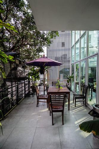 a patio with a table and chairs and an umbrella at Embryo Hotel  in Pattaya Central