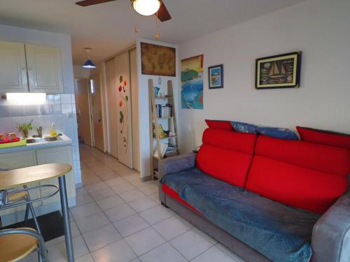un salon avec un canapé rouge et une cuisine dans l'établissement Appartement 2 pièces avec parking privé à Sète - FR-1-472-188, à Sète
