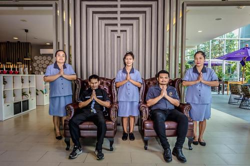 a group of men in blue shirts are sitting in chairs at Embryo Hotel  in Pattaya Central