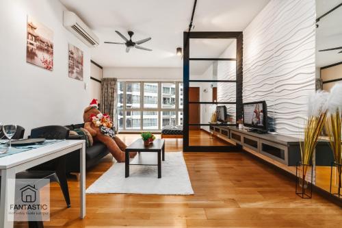 a living room with a person sitting on a couch at Regalia Residence by FANTASTIC in Kuala Lumpur