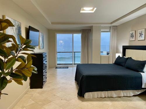 a bedroom with a bed with a view of the ocean at Amazing Ocean Front Condo in Rosarito