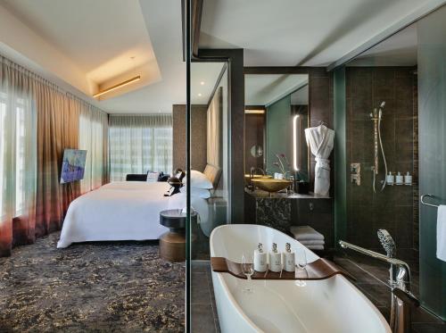a bathroom with a bed and a bath tub and a bathroom with a bath tub at SO/ Auckland in Auckland