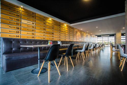 a bar with a row of chairs and a table at Embryo Hotel  in Pattaya Central