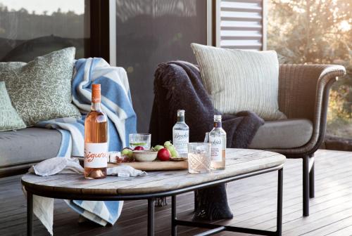 a living room with a table with two bottles of wine at Carinya Byron Bay in Hayters Hill