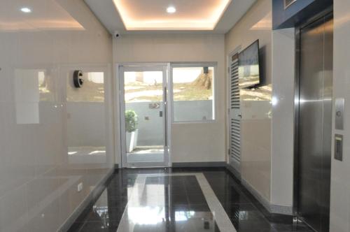 einen Flur mit weißen Wänden und einer Glastür in der Unterkunft Apparate Condotel Staycation in Cavite