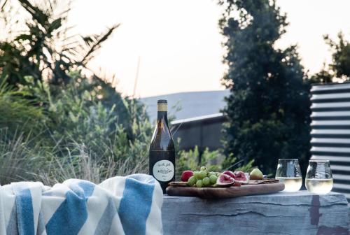 a bottle of wine and a plate of fruit on a table at Carinya Byron Bay in Hayters Hill