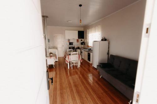 a living room with a couch and a kitchen at Ótimo custo benefício 2km centro wifi fogão lenha in Lages