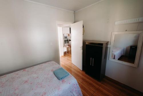a white bedroom with a bed and a mirror at Ótimo custo benefício 2km centro wifi fogão lenha in Lages