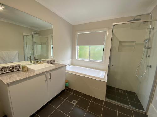 un bagno con vasca, lavandino e doccia di Camellia Cottage Pet Friendly Farm Stay a Picton