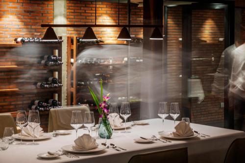 a table with a white table cloth and wine glasses at Farmhouse Resort & Spa in Kampong Chhnang