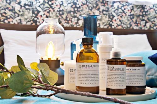 a table with bottles of essential oils and a candle at Tommy Condominium WAKASA301 in Kume