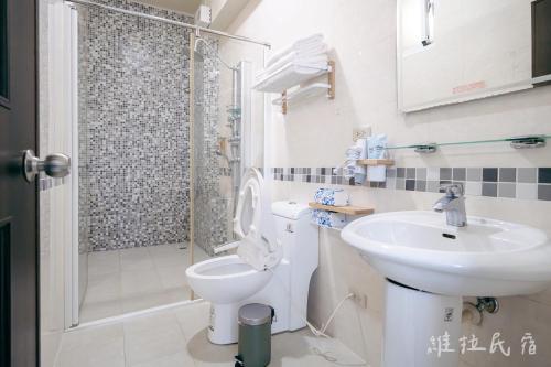 a bathroom with a sink and a toilet and a shower at 台東市區維拉包棟民宿 附廚房及電動麻將 in Taitung City