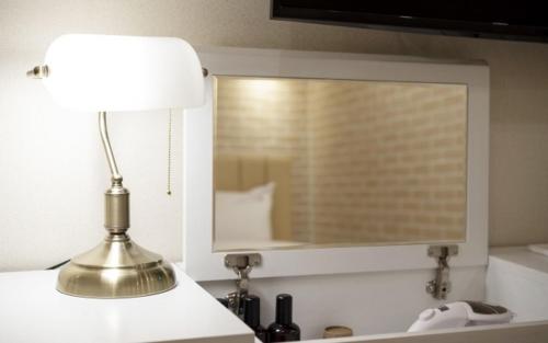 a lamp sitting on a counter with a mirror at Hotel Yaja Gwangalli in Busan